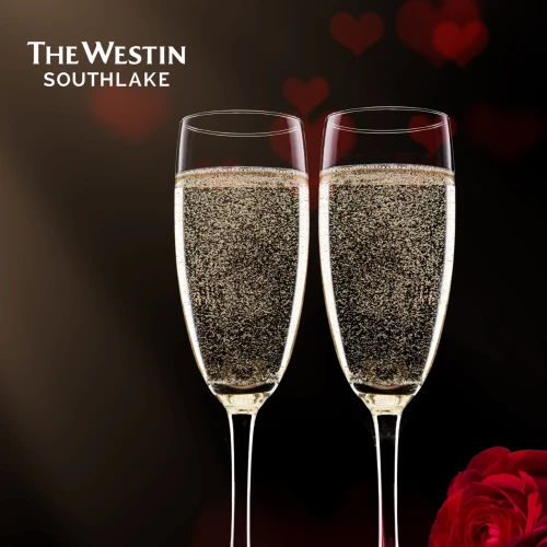 Two champagne flutes with bubbles, sitting on a red satin surface, a red rose beside them. The Westin Southlake logo is in the upper left corner.