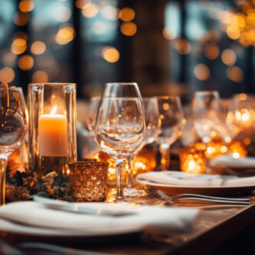 A beautifully set dining table with elegant glassware and candles, creating a warm and inviting atmosphere.